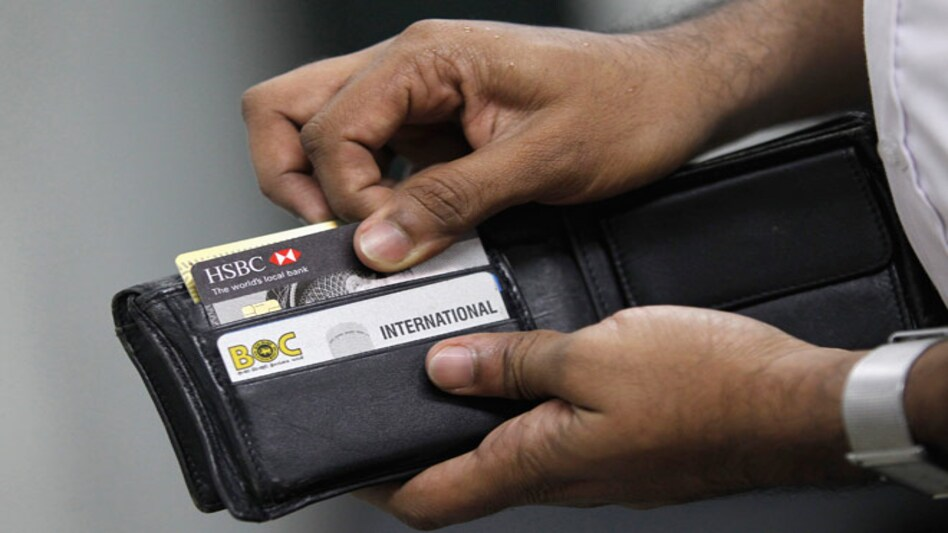 man opening wallet full of credit card